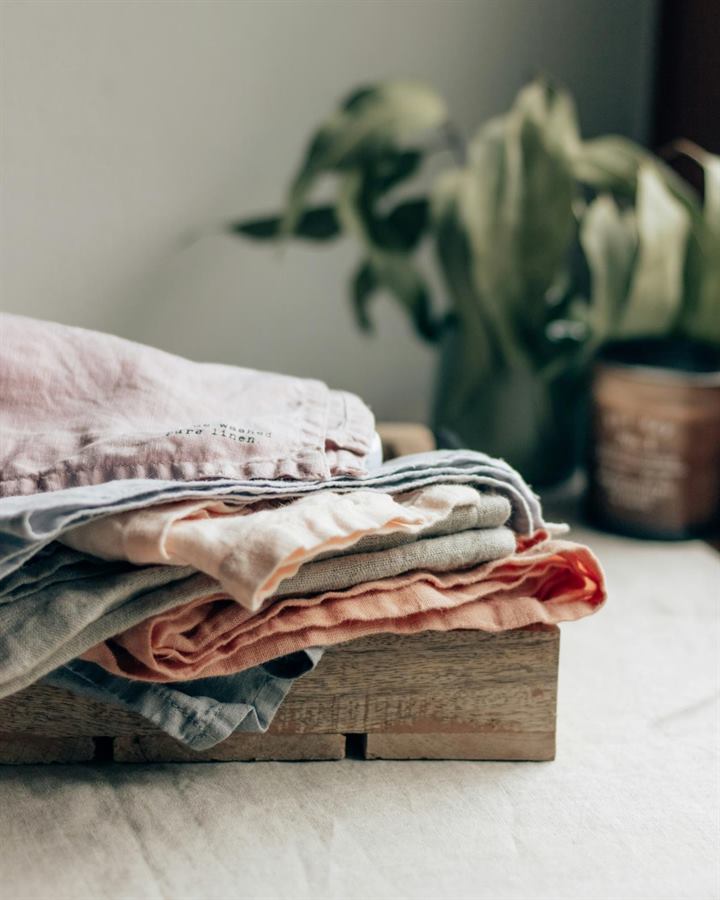 Folded linen stacked on a wooden tray