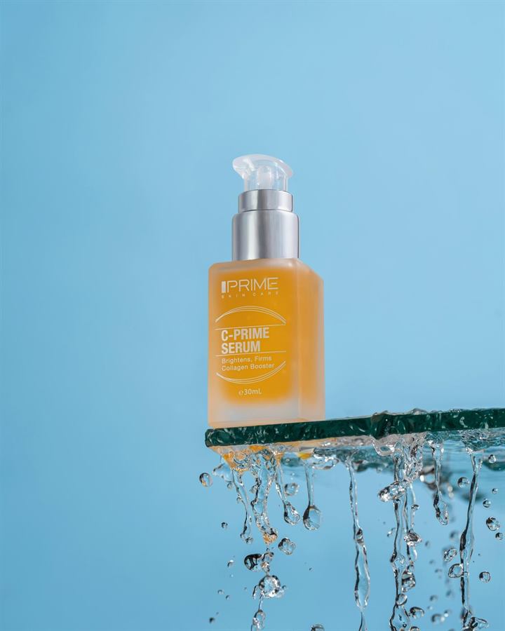 A serum bottle on a glass shelf with water running off it