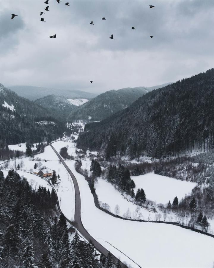 A snowy valley road seen from above